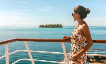 weekend caribbean cruises woman looking off of boat to small island trees